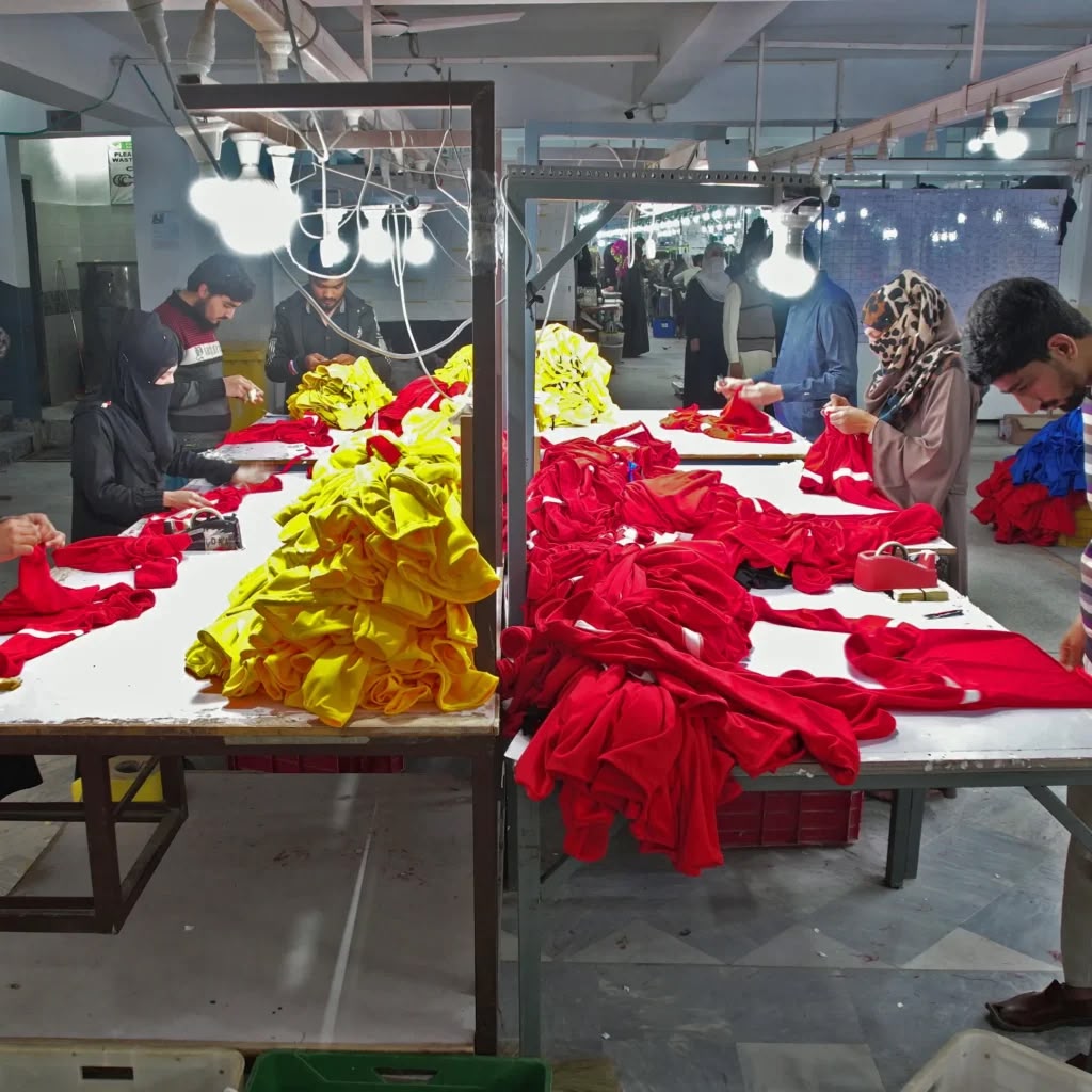 Production team sorting colorful garment panels at a worktable
