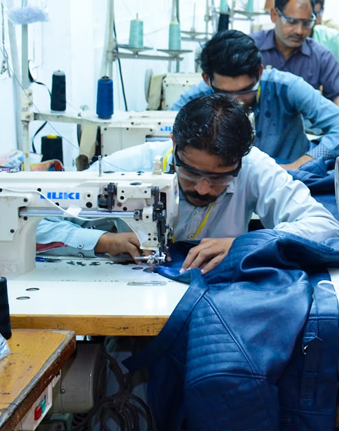 Production team sewing a blue quilted garment
